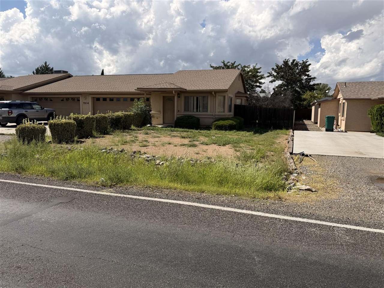 Overgrown, weedy front yard before a cleanup in Prescott Valley